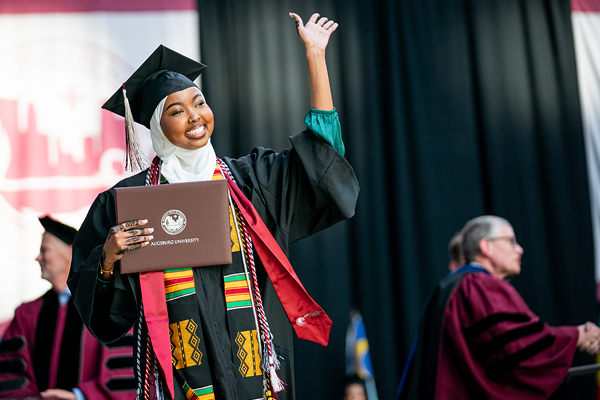 Abdi walks across the stage at Augsburg's commencement ceremony, 2023. (Photo by Courtney Perry)